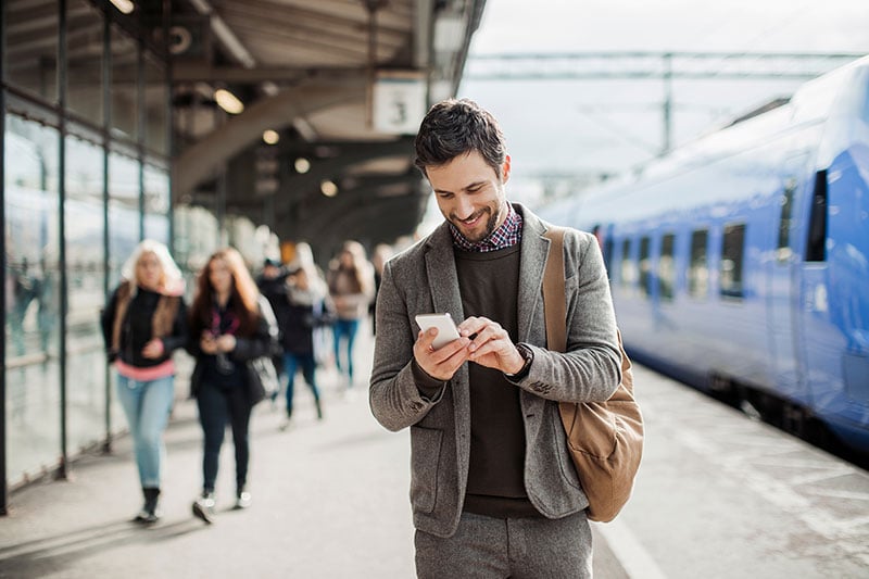 businessman-using-mobile-phone-at-train-station.jpg