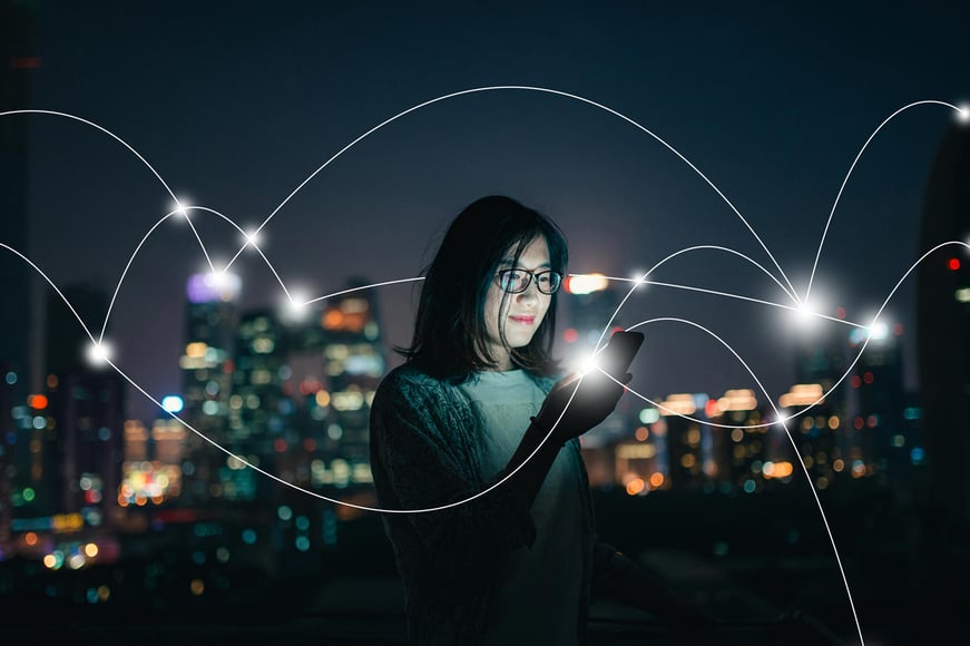 woman-holding-smartphone-city-night-network-connections.jpg