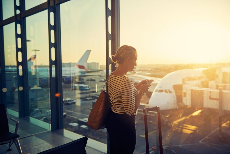 woman-using-smartphone-at-airport-with-planes.jpg